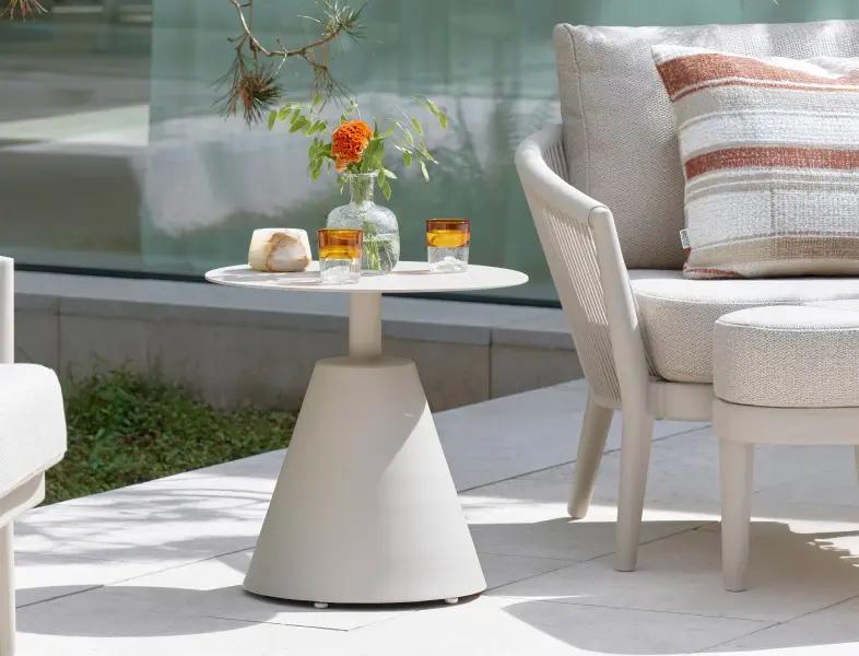 Une table d’appoint en aluminium beige sur une terrasse