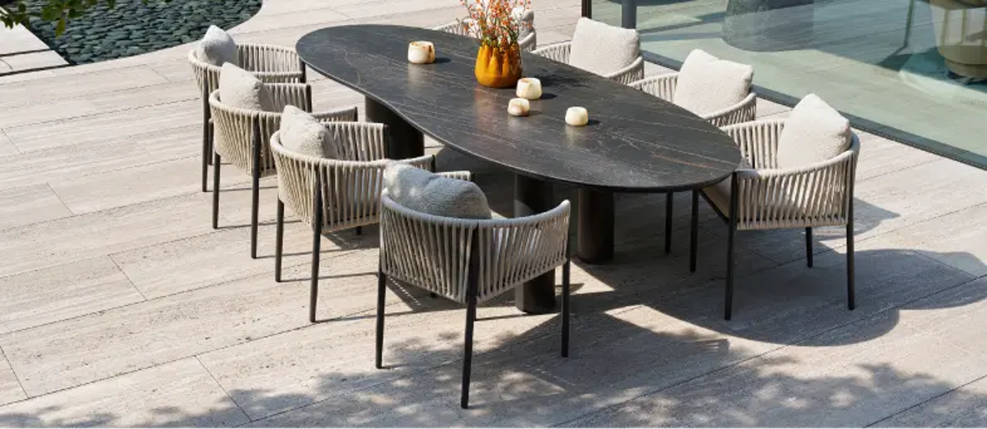 Een grote organische tafel op een zonnig terras van exterioo tuinmeubelen
