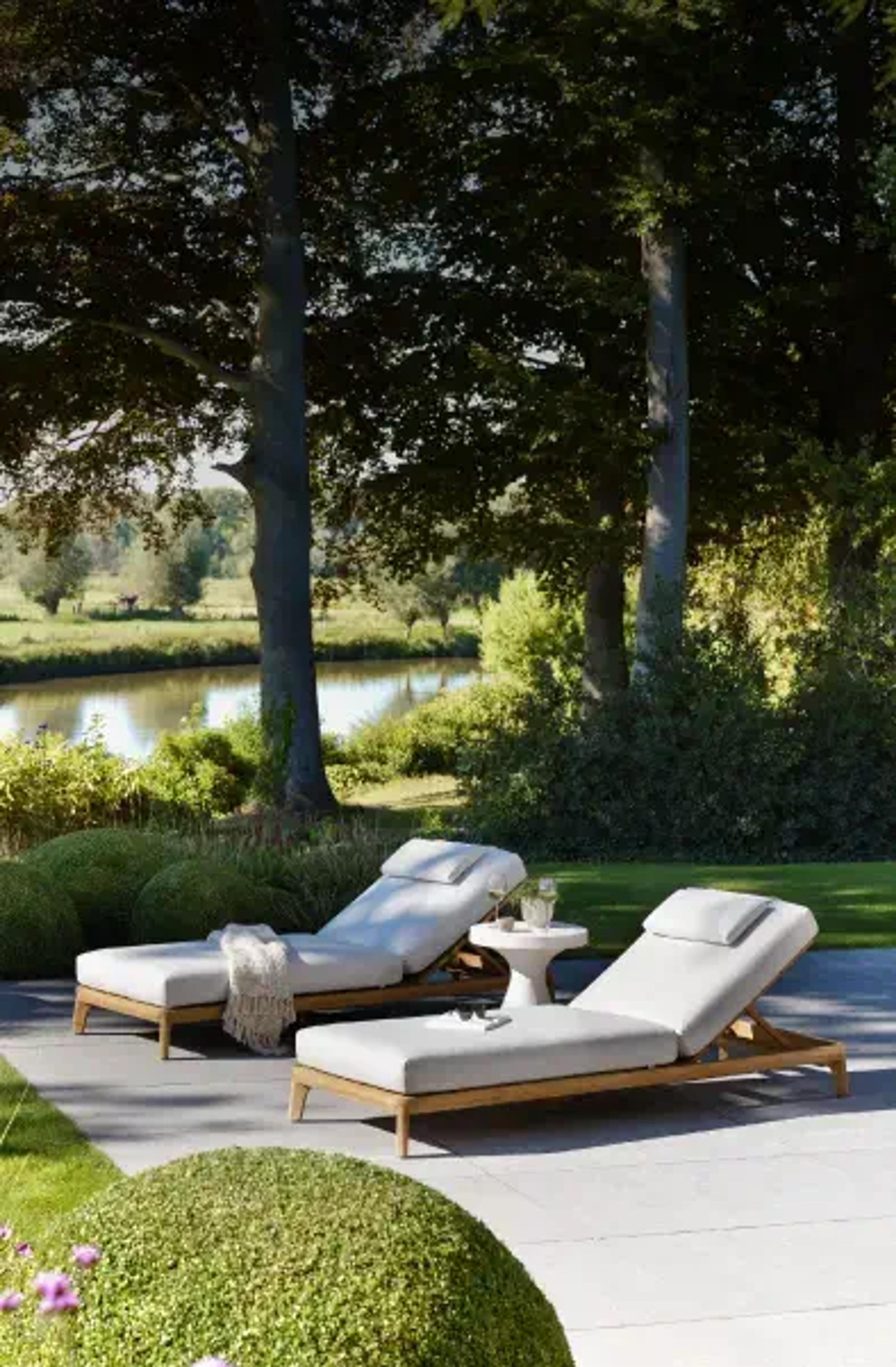 Ligstoelen met comfortabele kussens van Exterioo tuinmeubelen in een groene tuin