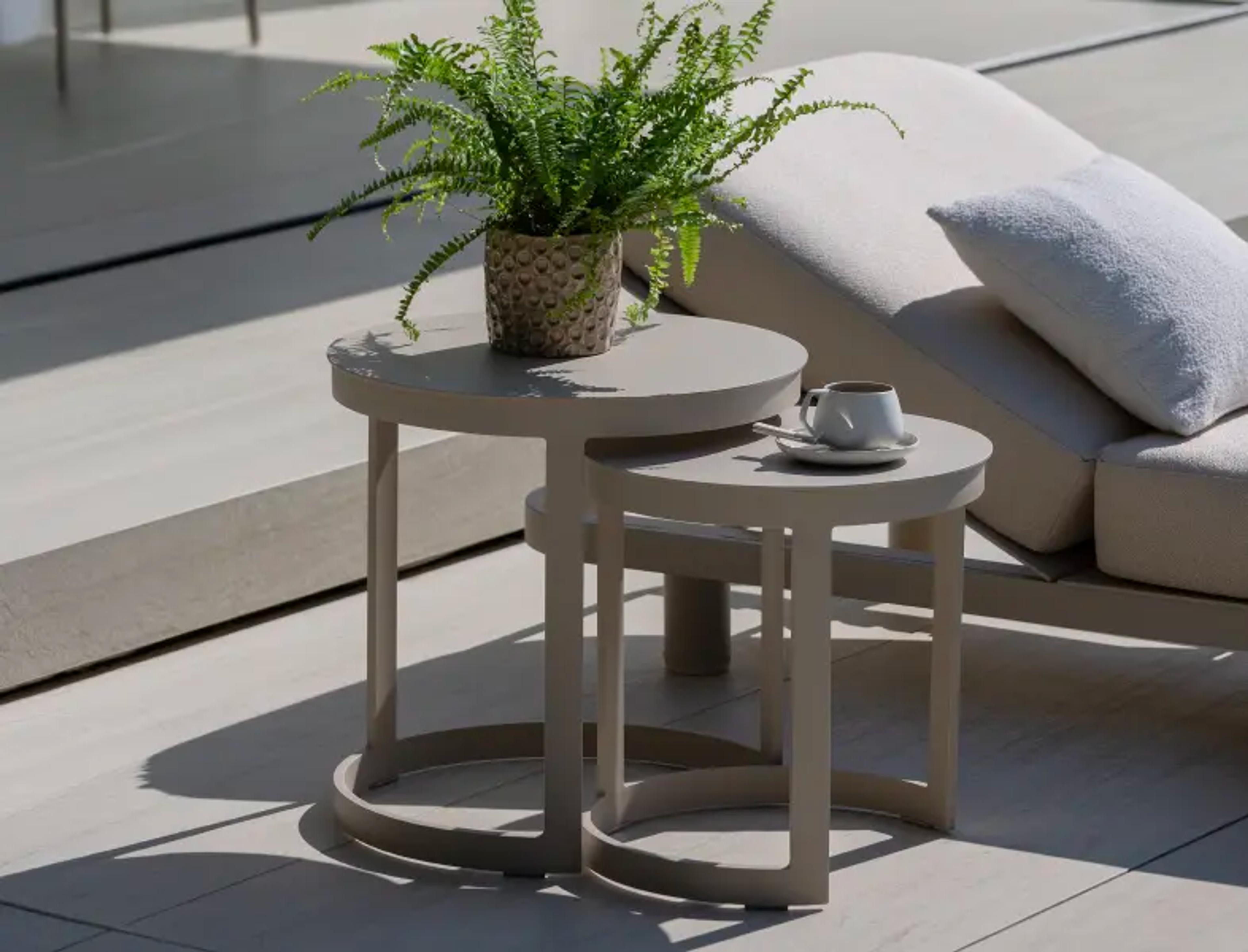 Deux tables d’appoint beige sur une terrasse