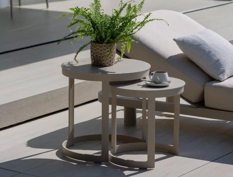 Deux tables d’appoint beige sur une terrasse
