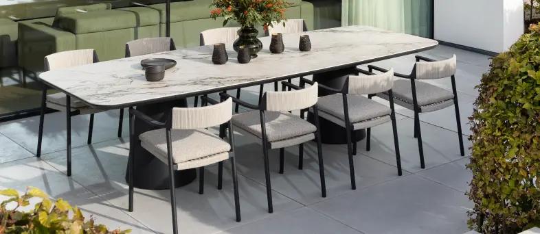 Een grote tuintafel met een keramisch blad in bootvorm van exterioo tuinmeubelen