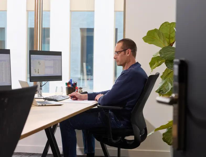 Een customer care medewerker achter zijn bureau