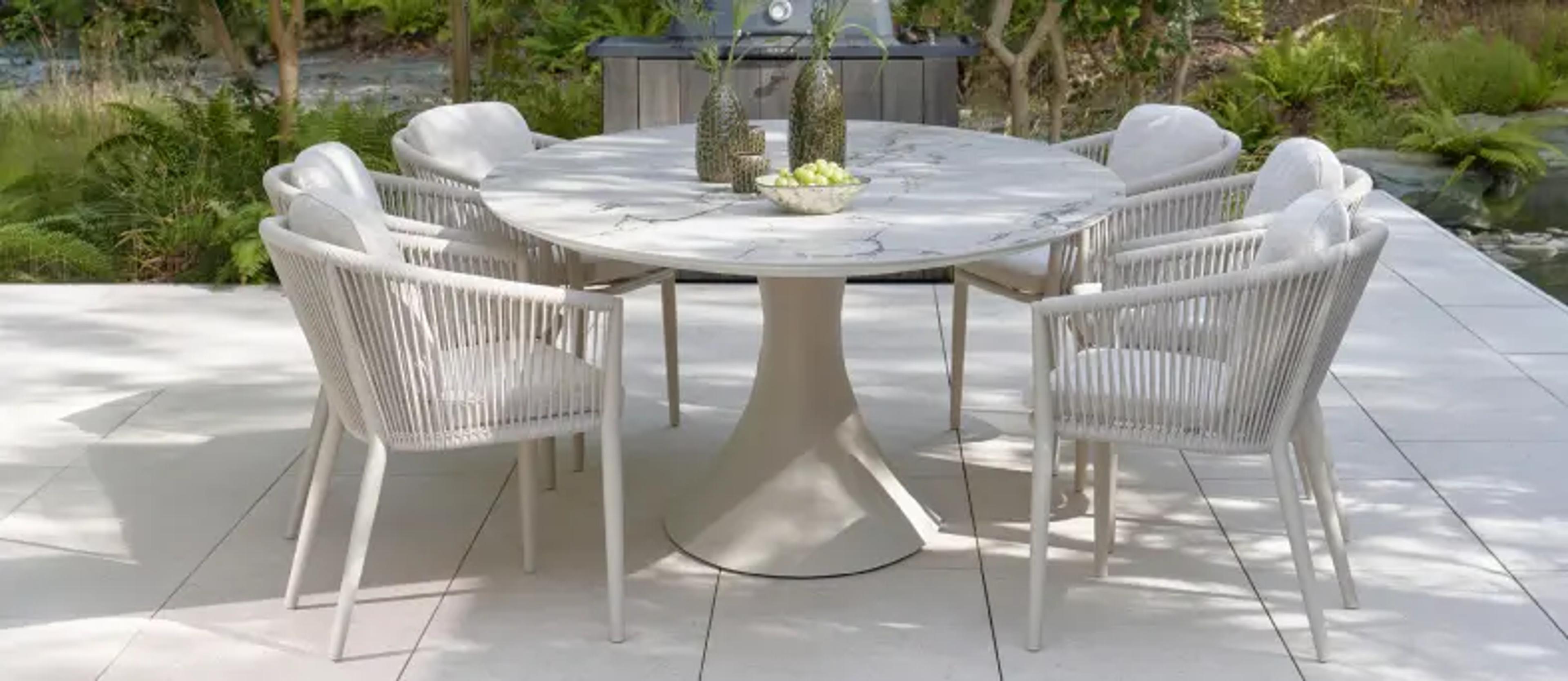 Une table ovale en céramique sur une terrasse ensoleillée d’Exterioo mobilier de jardin