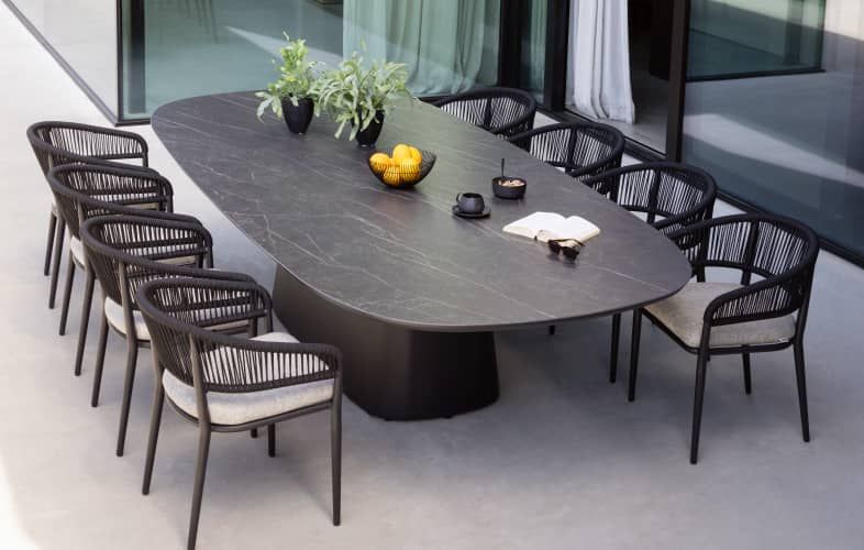 Een terras met een Orso tuintafel en 8 Orso tuinstoelen van exterioo tuinmeubelen.