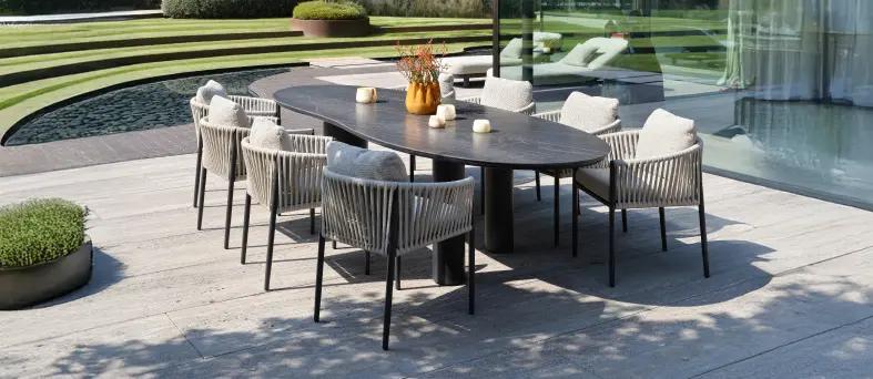 Terrasse d’été avec table de jardin en céramique et chaises en rope de la collection « Bristol à la carte » par Exterioo meubles de jardin.