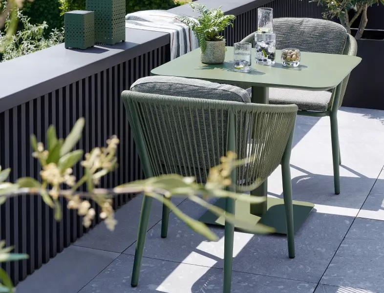 Een groene Fano bijzettafel met bijpassende Orso stoelen van Bristol à la carte door Exterioo tuinmeubelen