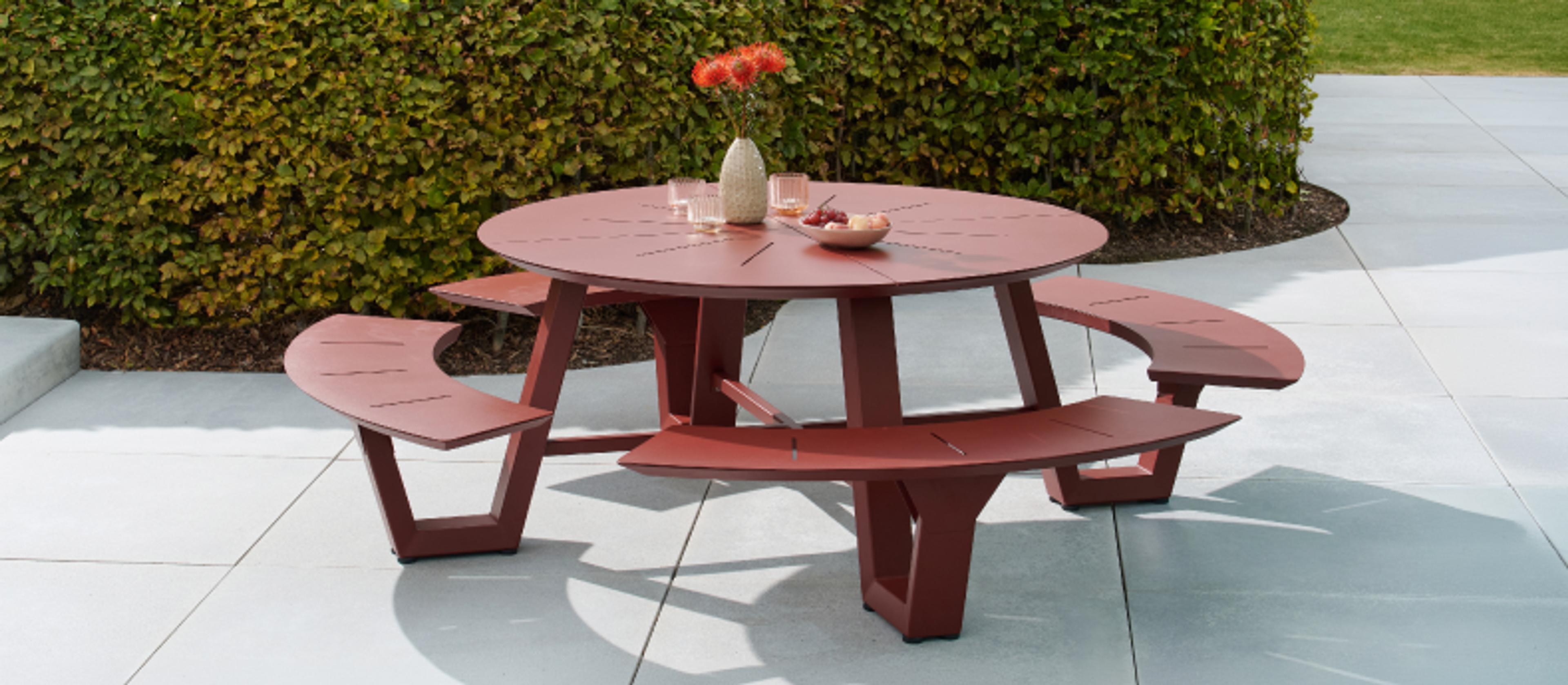 Une grande table de pique-nique de couleur foncée à l’ombre sur une terrasse par Exterioo meubles de jardin