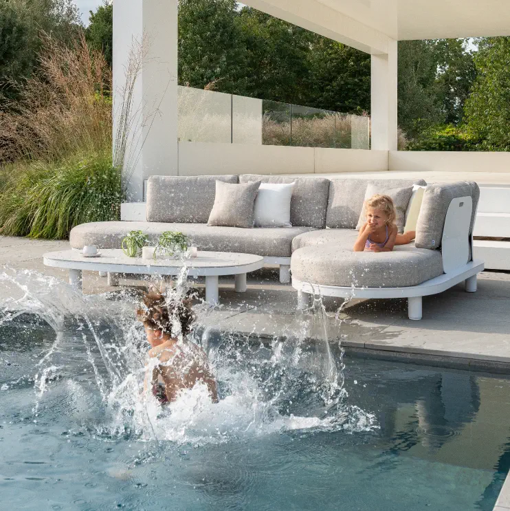 Een exterioo lounge op een zonnig terras langs het zwembad