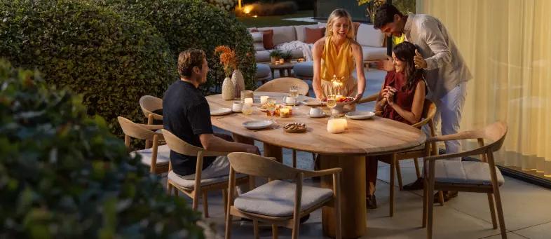 Gezellig samenzijn aan een teak tuintafel van Bristol à la carte door Exterioo tuinmeubelen