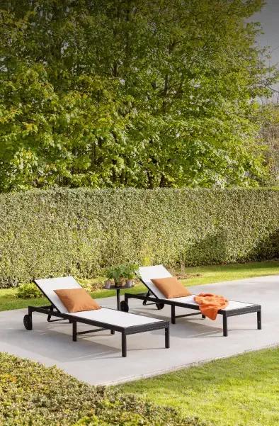 Ligbedden met comfortabele kussens van Exterioo tuinmeubelen in een groene tuin