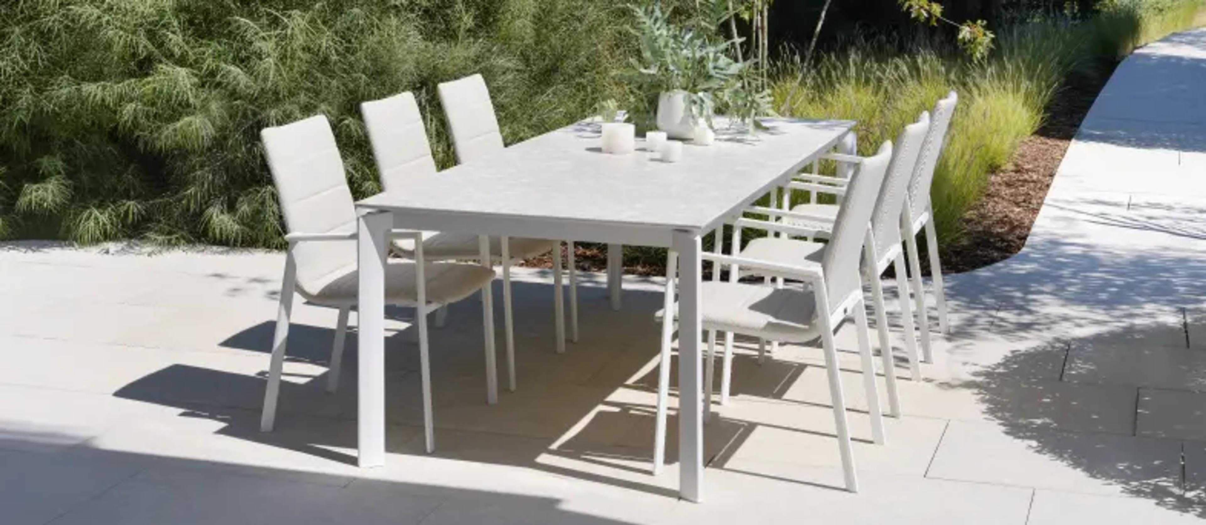 Een rechthoekige tuintafel op een zonnig terras van exterioo