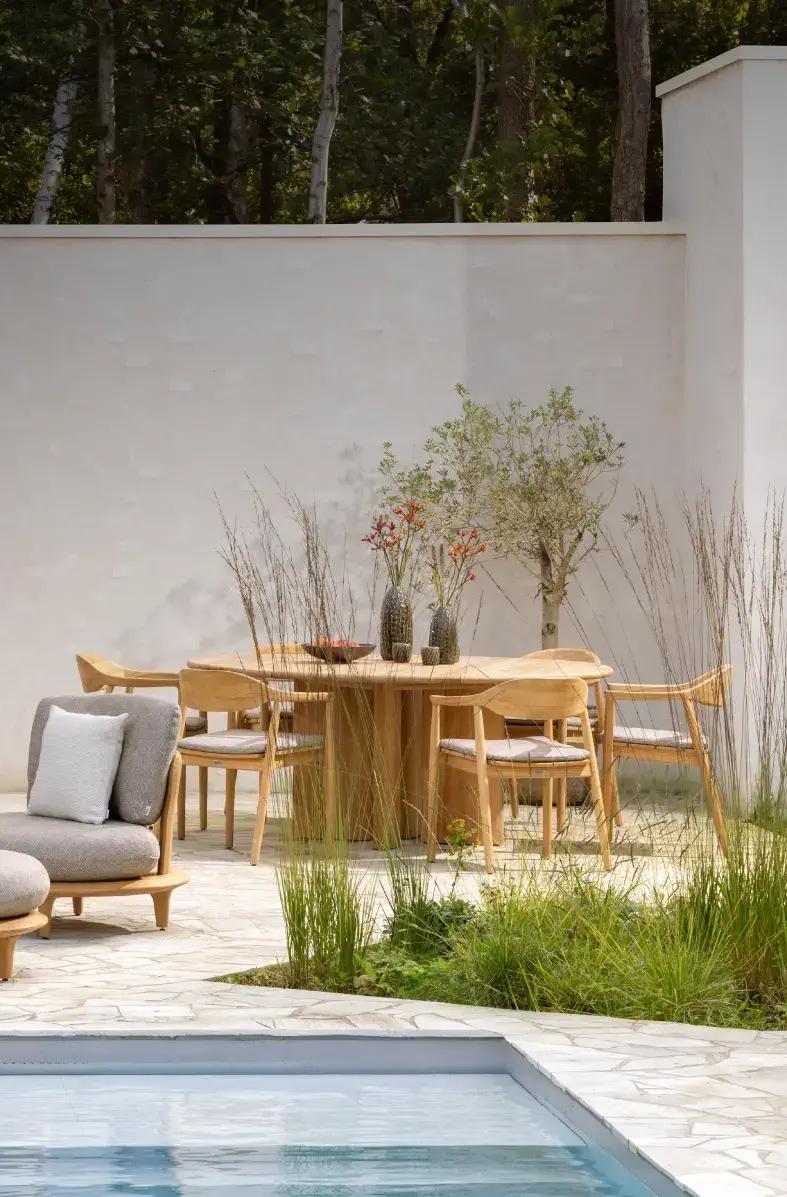 Teakhouten loungeset en tuinset van Exterioo tuinmeubelen op een stijlvol terras bij een zwembad