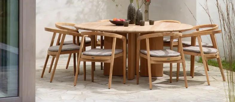 Een ronde teak tafel met 8 teak stoelen rond van exterioo tuinmeubelen