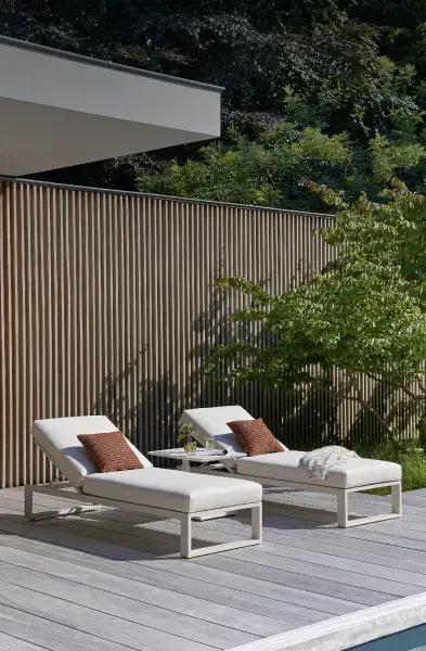 Ligbedden met comfortabele kussens van Exterioo tuinmeubelen in een groene tuin