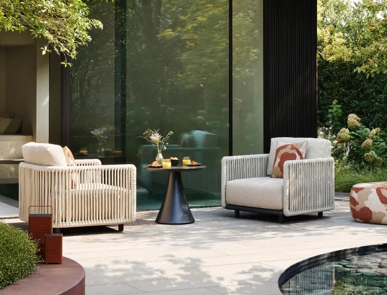Twee loungestoelen met een bijzettafel aan het zwembad van Bristol à la carte door Exterioo tuinmeubelen
