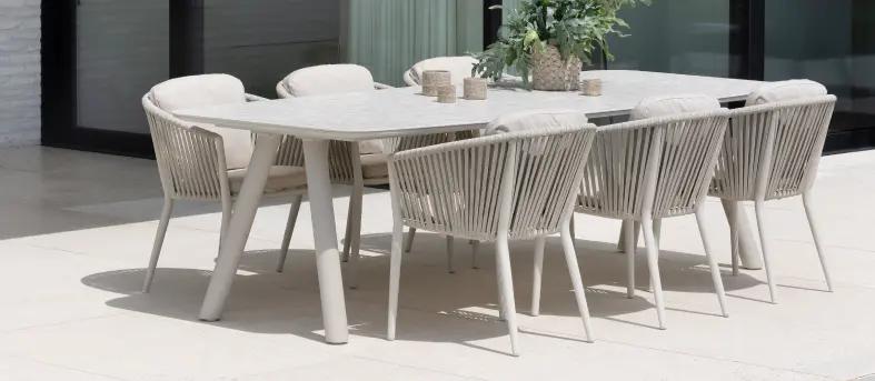 Een grote beige tuintafel met keramische blad en 6 stoelen van exterioo tuinmeubelen