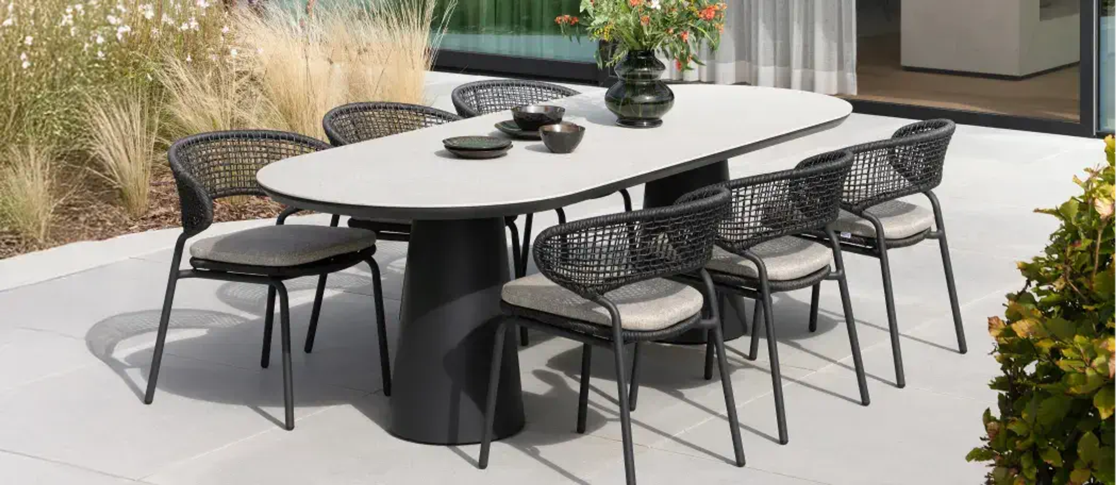 Terrasse ensoleillée avec une table en céramique pleine et des chaises de jardin Bristol à la carte par Exterioo meubles de jardin